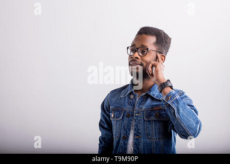 Thoughtful clever handsome african man student touching head with finger and gazing left while thinking, making decision, having new idea, wearing den Stock Photo