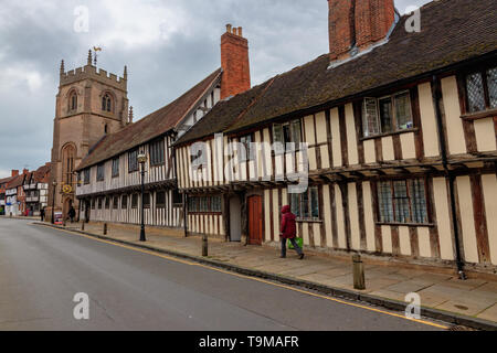 Lone figure in raincoat walking along Church Street, Stratford Upon Avon Stock Photo