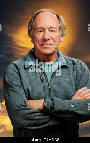 Portrait of confident middle aged man against sunset clouds background Stock Photo