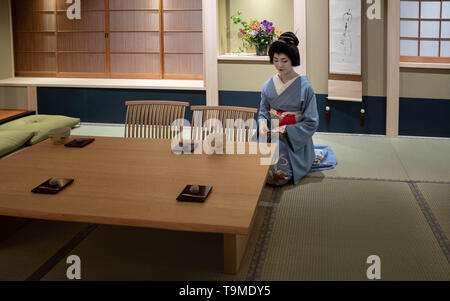 Kyoto, Japan - May 19, 2019: Maiko studies notes in preparation for traditional tea ceremony Stock Photo