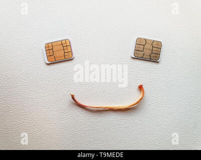 two micro sim cards lying in the shape of a sad face Stock Photo