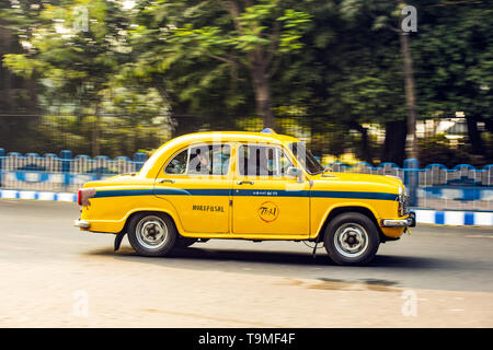 An Ambassador cab taxi with passengers on board is running on the streets of Kolkata. Stock Photo