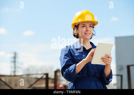 Female Worker Using Tablet Outdoors Stock Photo