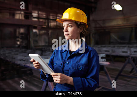 Female Worker Using Tablet in Workshop Stock Photo