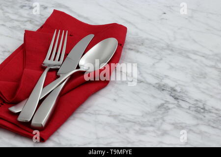 trendy and beautiful silverware set styled on linen double hemstitch napkin and antique carrara marble Stock Photo