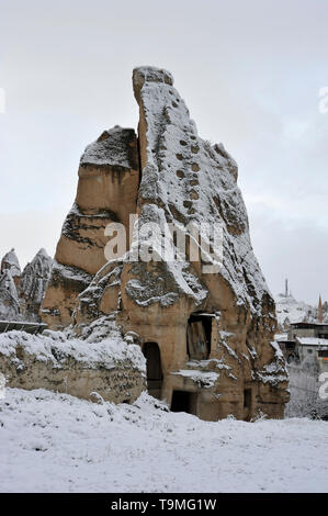 Unusual natural stone formations with snow in Goreme in the Cappadocia region of Turkey Stock Photo