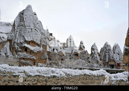 Unusual natural stone formations with snow in Goreme in the Cappadocia region of Turkey Stock Photo