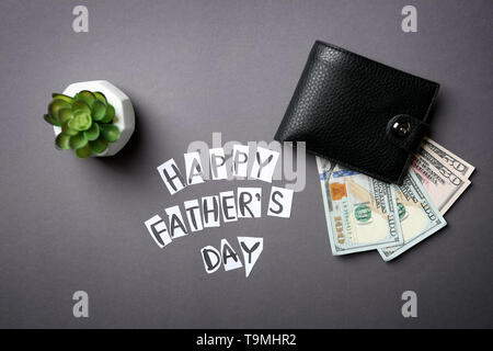 Wallet with money and text HAPPY FATHER'S DAY on grey background Stock Photo