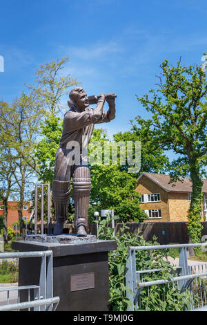 Bronze statue of cricket player Eric Bedser on Bedser Bridge, a footbridge on the Basingstoke Canal linking the WWF-UK headquarters to the town centre Stock Photo