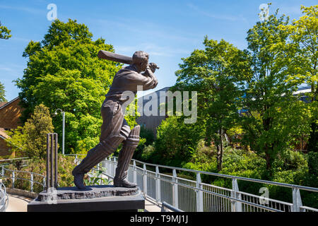 Bronze statue of cricket icon Eric Bedser on Bedser Bridge, a footbridge over the Basingstoke Canal linking the WWF-UK headquarters to the town centre Stock Photo