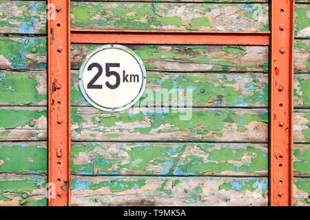 Isolated round metal speed limit 25 km sign on weathered colorful wooden planks with peeling paint on back of agricultural trailer -  Brüggen, Germany Stock Photo