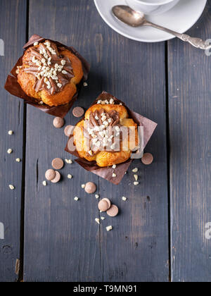 Homemade vanilla muffin and white cup on wooden background. Top view Stock Photo