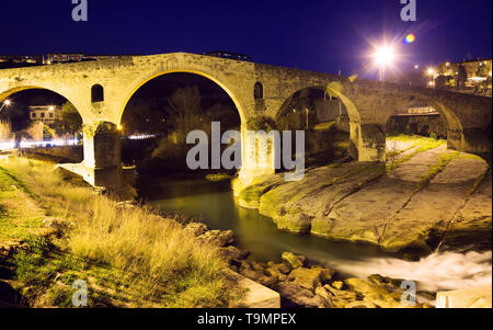 Stone bridge near Cave of Saint Ignatius with lights in evening in Manresa Stock Photo