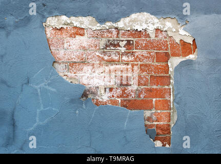 Brick wall with peeling paint and plaster in need of repair