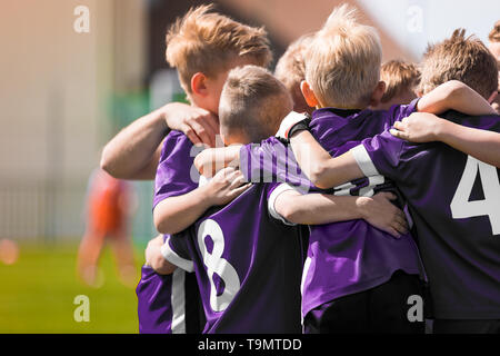 Group of children in soccer football team standing together before the final game. Boys motivating each other and building sports team spirit Stock Photo
