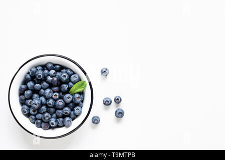 Organic blueberries in bowl on white background. Table top view. Copy space for text Stock Photo