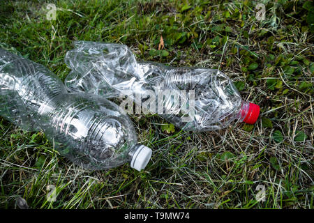 crumpled plastic bottles on the grass, plastic pollution Stock Photo