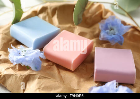 Different soap bars with flowers on crumpled paper Stock Photo