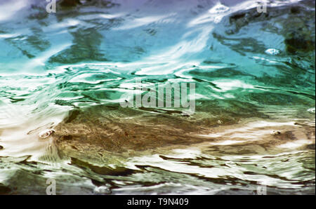 Beautiful colors of green and blue on surface of rippling lake waters Stock Photo