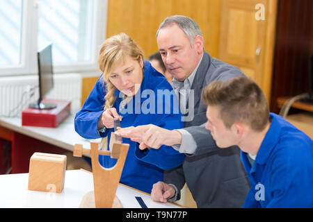 carpenter with students in woodworking workshop Stock Photo