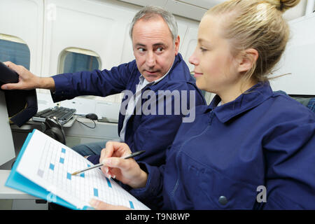 male and female mechanic team doing checklist in workshop Stock Photo