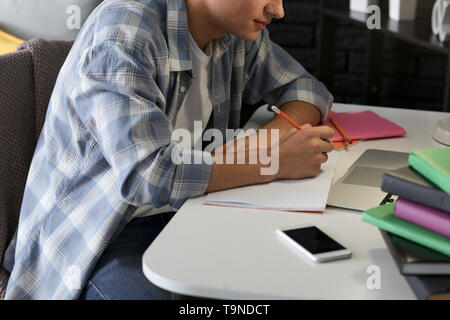 Male student preparing for exam at home Stock Photo