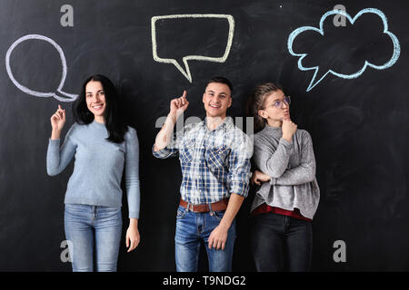 People and blank speech bubbles on dark background Stock Photo
