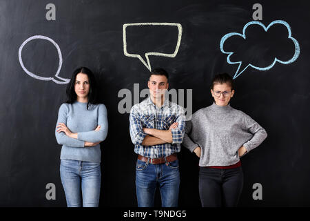 Emotional people and blank speech bubbles on dark background Stock Photo