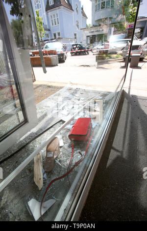 20 May 2019, Hamburg: Expenses lie between pieces of broken glass in a shop window in a fashion store in Hamburg. An over 80-year-old woman drove her car into the shop window of a fashion store in Hamburg's Groß Flottbek district. The senior woman was slightly injured in the accident on Monday morning and taken to a hospital, a spokesperson for the fire brigade said. Emergency personnel should've gotten them out of the car. Photo: Bodo Marks/dpa Stock Photo