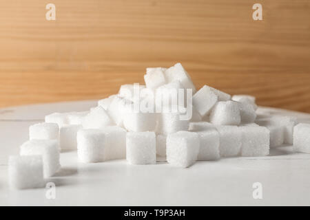 Heap of refined sugar cubes on table Stock Photo