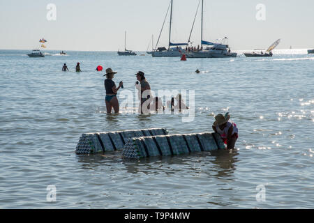 Darwin, Northern Territory, Australia-July 22,2018: Person pushing can raft during the Beer Can Regatta at Mindil Beach in the NT of Australia Stock Photo