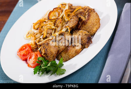 Delicious stir fried rabbit liver with onion served on white plate with cherry tomatoes and parsley Stock Photo