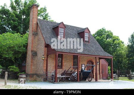 American colonial architecture: a brick farmhouse with an open storage shed Stock Photo