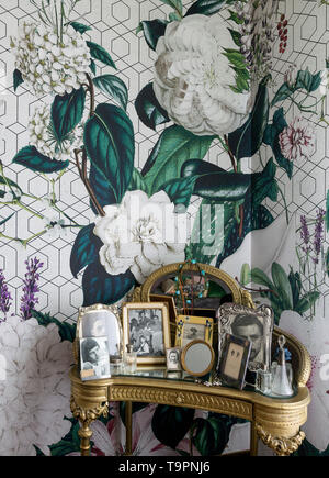 Vanity table with mirror  in the corner of a bed room with wallpaper on the wall Stock Photo