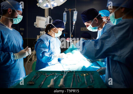 Team of surgeons over operating table during serious operation Stock Photo