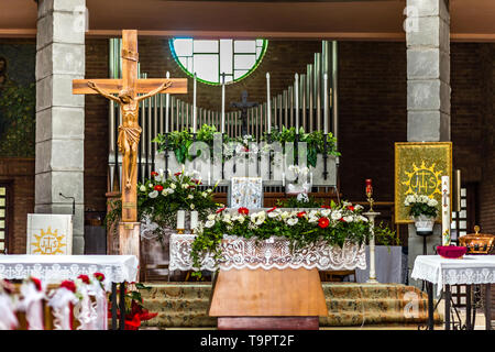 SAN BERNARDINO (RA), ITALY - MAY 20, 2019: sun is enlightening altar and flower decorations on benches in Parish Catholic Church Stock Photo