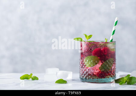 Raspberry cocktail, fizz, lemonade, ice tea with fresh mint on marble background. Copy space. Stock Photo