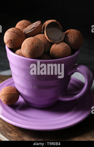 Cup with sweet truffles on table Stock Photo
