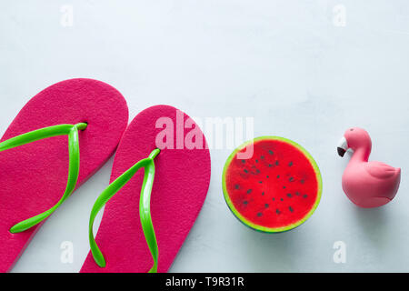 pink beach flip flops  and squishy toy watermelon  and flamingo  on white  background copy space Stock Photo