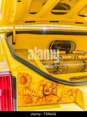 A detail of the trunk of a bright yellow Chevrolet lowrider