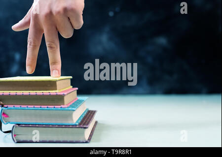 Success concept with fingers climbing stairs made of books stack Stock Photo