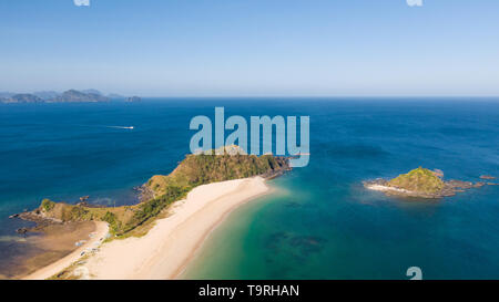 Wide tropical beach with white sand and small islands, top view. Nacpan Beach El Nido, Palawan. Seascape in clear weather, view from above.