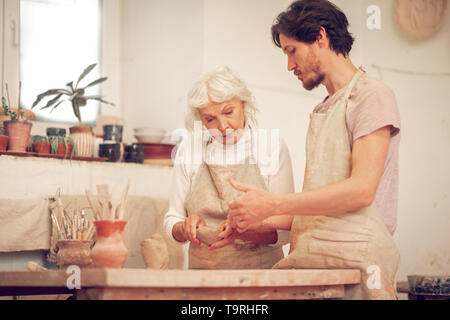 Pleasant young man asking a question to the teacher Stock Photo