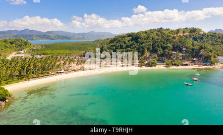 Las Cabanas Beach. Islands and beaches of El Nido.Tropical islands with white sandy beaches, aerial view.Tourists relax on the white beach. Stock Photo