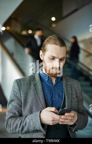 Businessman using mobile app on gadget Stock Photo