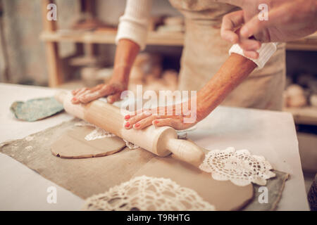 Close up of a rolling pin in female hands Stock Photo