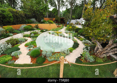 The Dubai Majlis Garden (designed by Thomas Hoblyn), one of the eleven beautiful and elegant show gardens on display at the 2019 RHS Chelsea Flower Show which opened today in the 11-acre grounds of the Royal Hospital Chelsea, London, United Kingdom - 20 May 2019  The garden is inspired by the sculptural beauty found in arid landscapes, from wind-blown sand dunes and fluvially eroded rock to the manmade hillside terraces and the goat-browsed topiary-esque plants that colonise them. A sand-dune-inspired pavilion is the main destination and provides a calm and contemplative space for young people Stock Photo