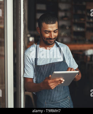 Young male entrepreneur using digital tablet at the cafe entranc Stock Photo