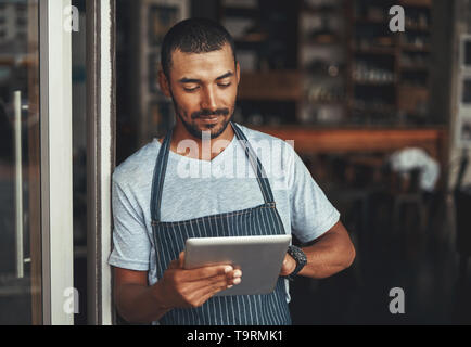 Young male cafe owner using digital tablet Stock Photo