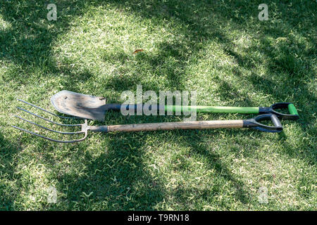 Shovel and pitchfork on green grass Stock Photo